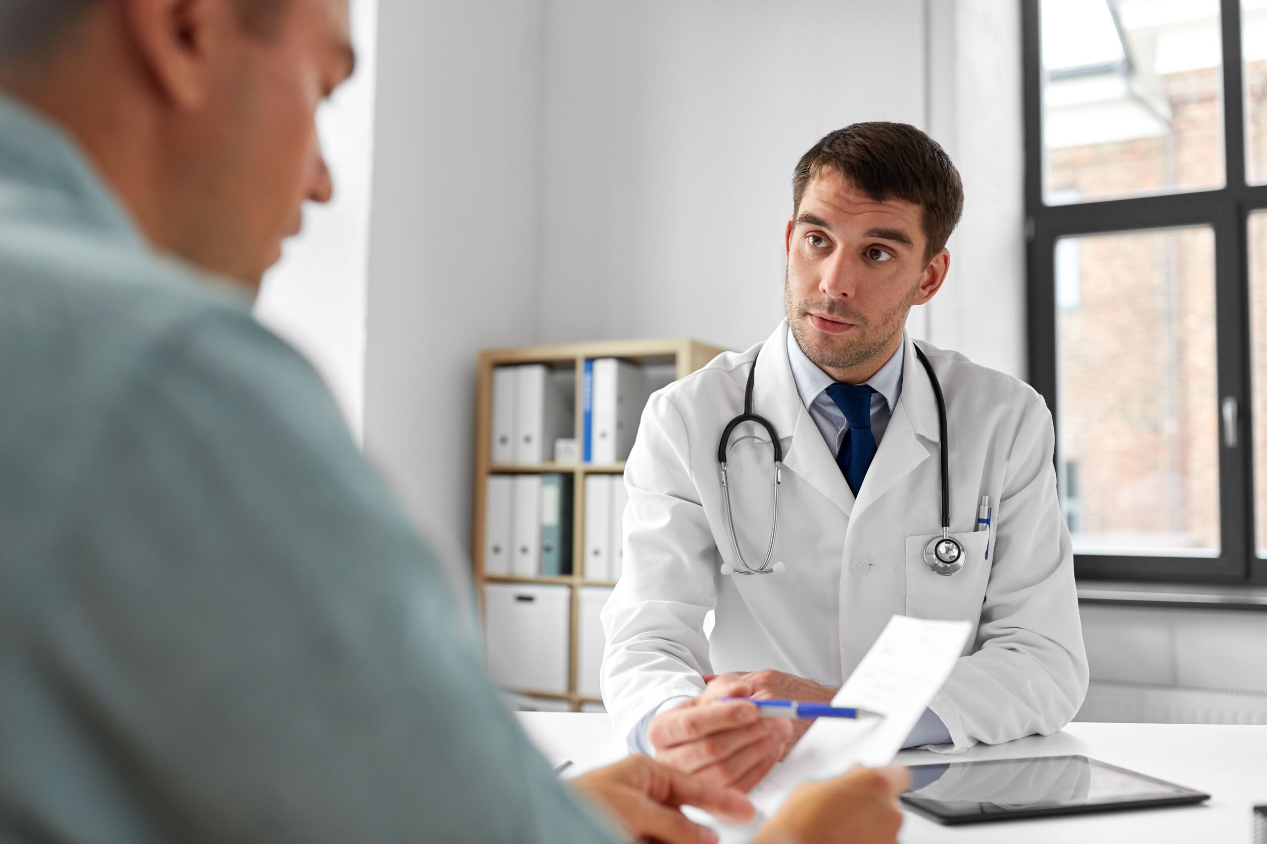 doctor giving prescription to patient at medical office in hospital
